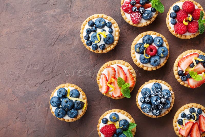 Tartlets o torta del verano con la opinión superior del queso cremoso y de la baya mezclada Postres sabrosos de los pasteles imagen de archivo Tartlets o torta del verano con la opinión superior del queso cremoso y de la baya mezclada Postres sabrosos de los pasteles imagen de archivo