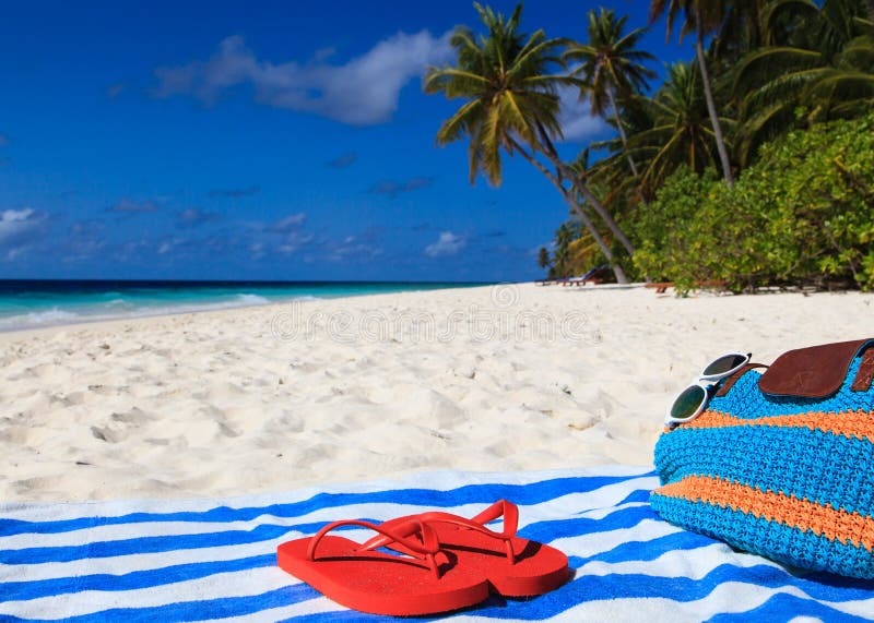 Bag, towel and flip flops on a tropical beach vacation. Bag, towel and flip flops on a tropical beach vacation