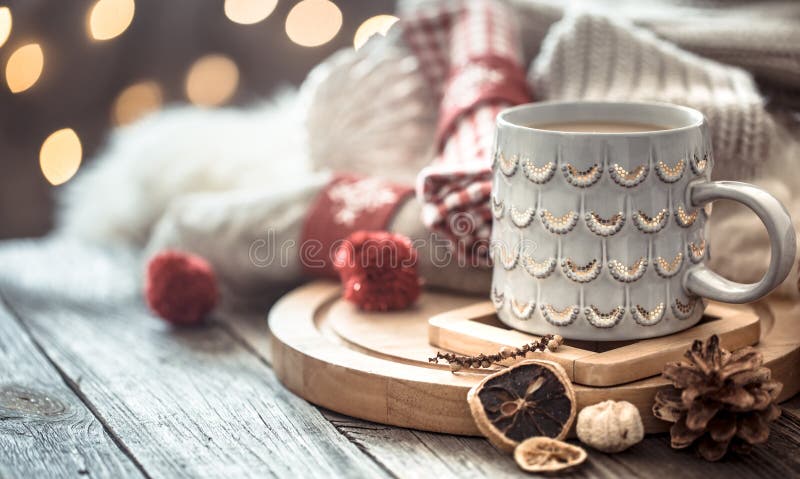 Tasse de café au-dessus de bokeh de lumières de Noël dans la maison sur la table en bois avec le chandail sur un fond et des déco images libres de droits Tasse de café au-dessus de bokeh de lumières de Noël dans la maison sur la table en bois avec le chandail sur un fond et des déco images libres de droits