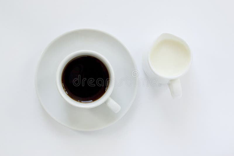 Tasse de café d'expresso avec la soucoupe et un petit broc de lait sur le fond blanc Vue sup?rieure Fermez-vous vers le haut de l photographie stock libre de droits Tasse de café d'expresso avec la soucoupe et un petit broc de lait sur le fond blanc Vue sup?rieure Fermez-vous vers le haut de l photographie stock libre de droits