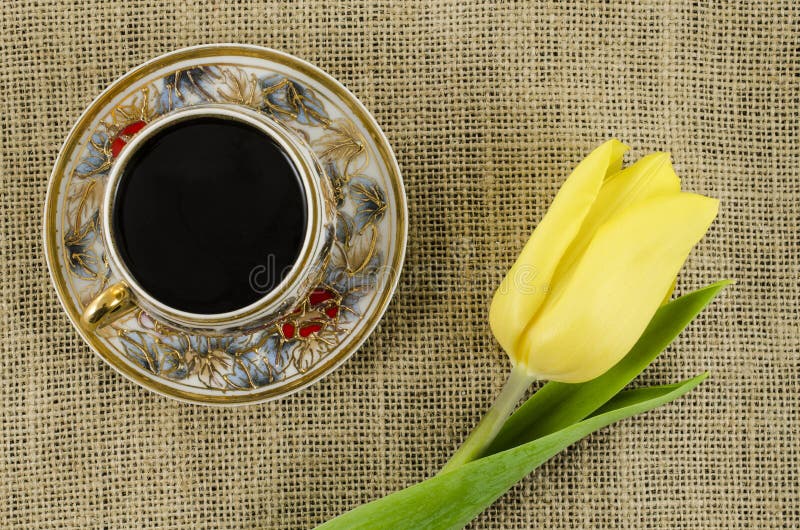 Tasse de café de porcelaine avec la fleur jaune sur le fond de toile photos libres de droits Tasse de café de porcelaine avec la fleur jaune sur le fond de toile photos libres de droits