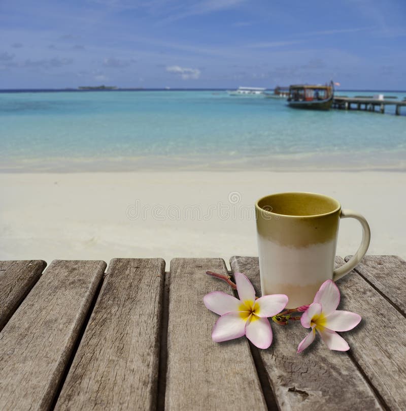 Tasse de café sur la vieille table en bois placée sur la plage photo libre de droits Tasse de café sur la vieille table en bois placée sur la plage photo libre de droits