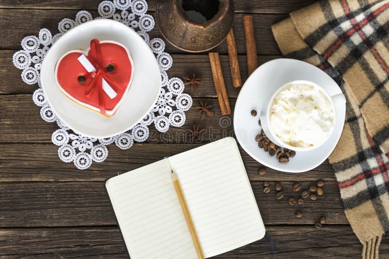 Tasse de cappuccino, pots en forme de coeur de message, de carnet, de crayon et de café de largeur de biscuits sur une table en b image libre de droits Tasse de cappuccino, pots en forme de coeur de message, de carnet, de crayon et de café de largeur de biscuits sur une table en b image libre de droits