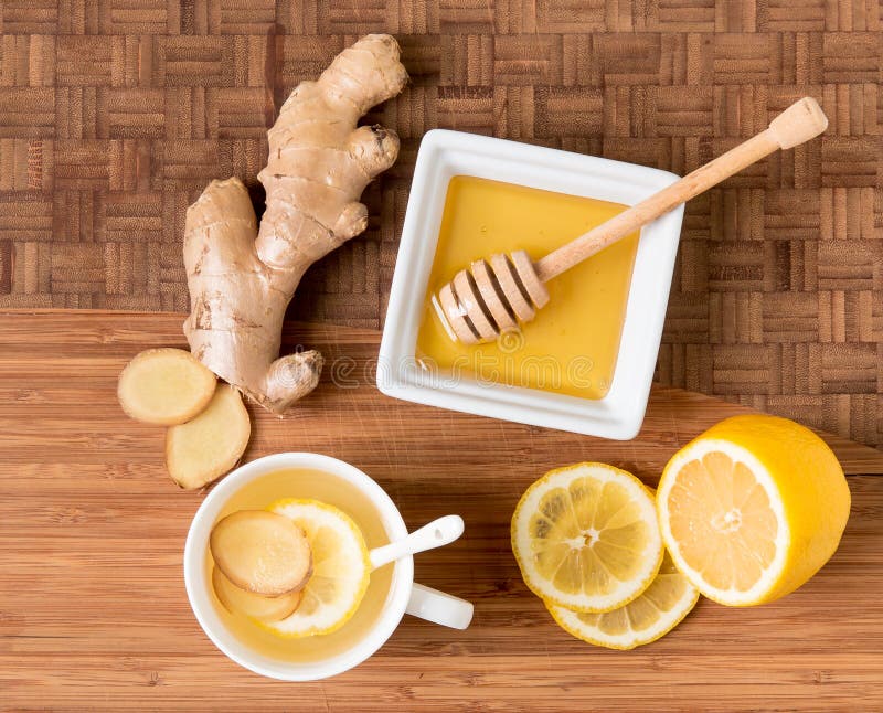 Tasse de thé avec la racine, le citron et le miel frais de gingembre sur le Cu en bois photo libre de droits