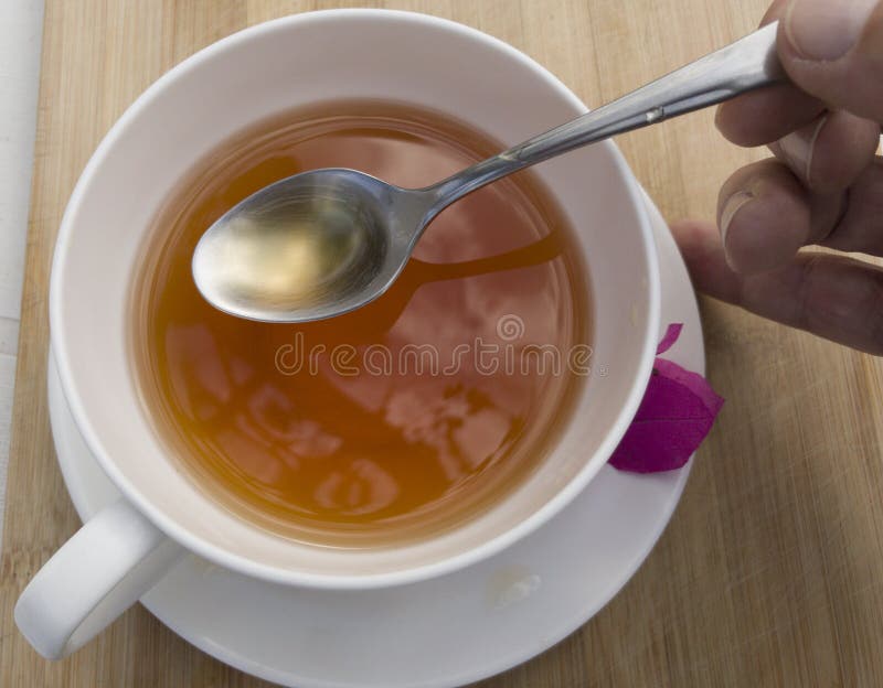 Tasse de th? blanche avec la tisane et une cuill?re d'argent photo libre de droits Tasse de th? blanche avec la tisane et une cuill?re d'argent photo libre de droits