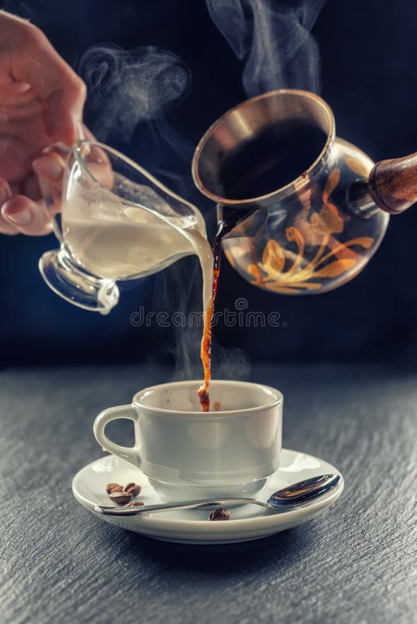 Tasse de versement de café et de lait chauds photos stock Tasse de versement de café et de lait chauds photos stock