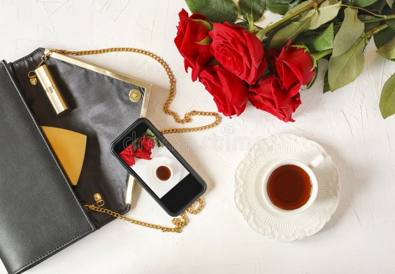 Tasse Tee, Frau ` s Tasche und rote Rosen auf weißem Hintergrund flach lizenzfreies stockbild Tasse Tee, Frau ` s Tasche und rote Rosen auf weißem Hintergrund flach lizenzfreies stockbild