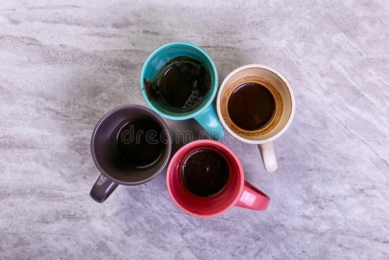 Tasses de café sales vides de différentes couleurs sur la table Concept de dopant de caféine, manque d'énergie et longue attente photos stock Tasses de café sales vides de différentes couleurs sur la table Concept de dopant de caféine, manque d'énergie et longue attente photos stock