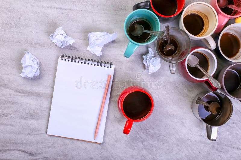 Tasses de café sales vides, différentes couleurs sur la table et un carnet pour écrire une lettre Dopant de caféine de concept, m photo stock Tasses de café sales vides, différentes couleurs sur la table et un carnet pour écrire une lettre Dopant de caféine de concept, m photo stock