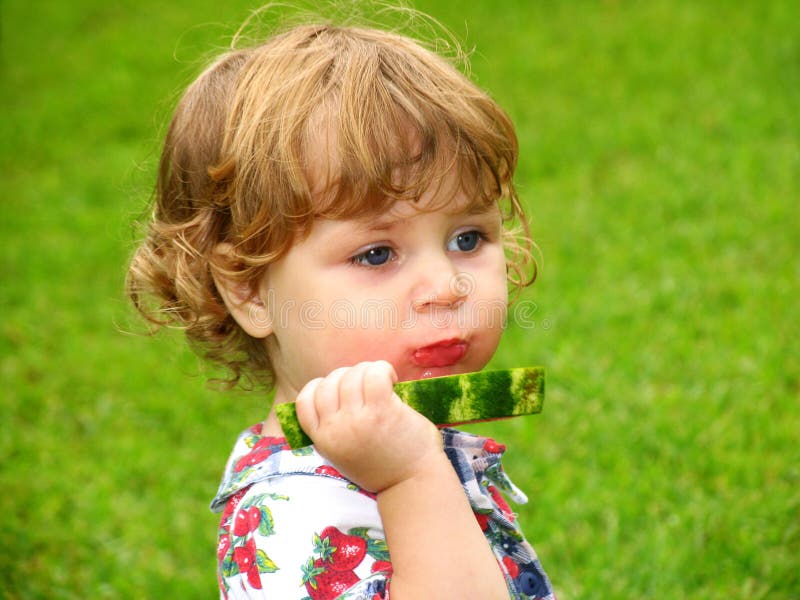 Malé dievčatko sa teší plátok melóna.