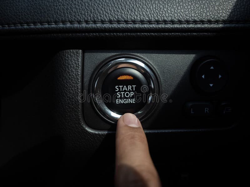 Tasto del motore di arresto con luce arancione sullo sfondo della console dell'auto nera immagini stock libere da diritti Tasto del motore di arresto con luce arancione sullo sfondo della console dell'auto nera immagini stock libere da diritti