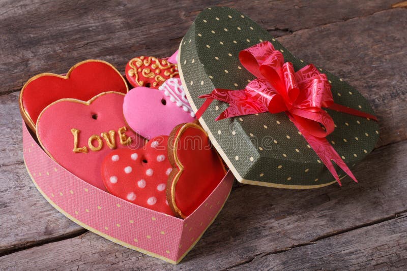 Tasty cookies in valentines heart shaped box on a wooden table