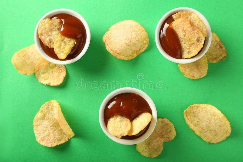 Tasty Crispy Potato Chips with Sauces on Color Background, Top View