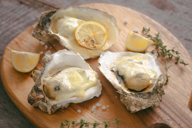 Tasty fresh oysters with sliced lemon on cutting board. Aphrodisiac food for increasing sexual desire.  stock photo
