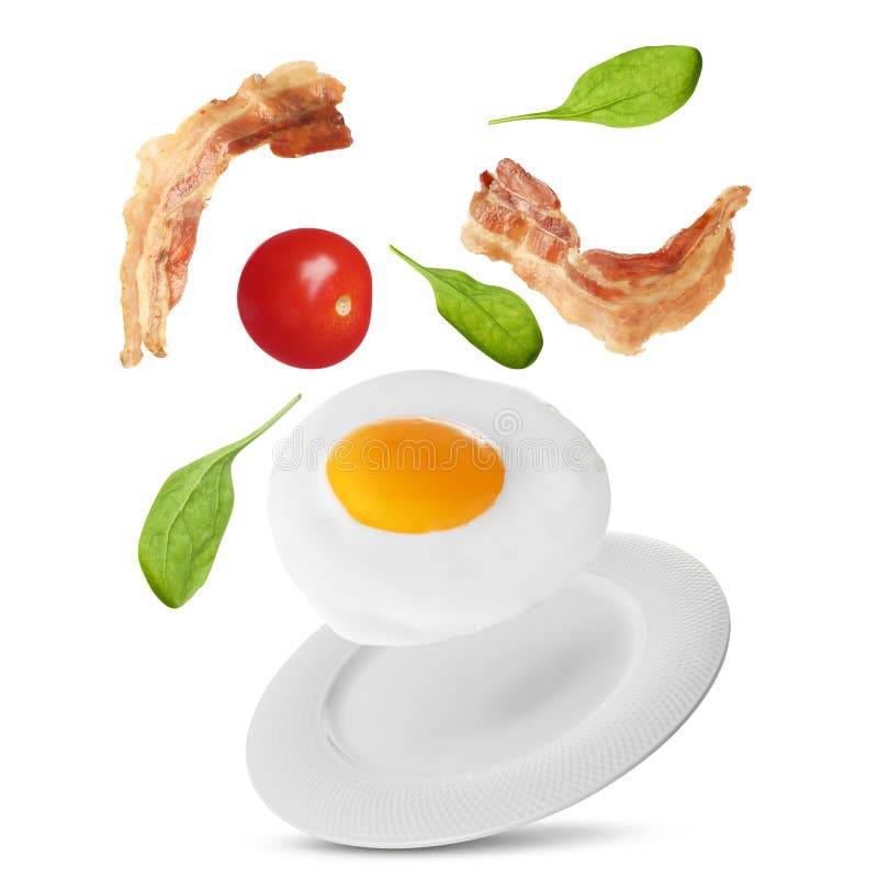 Tasty Fried Chicken Egg, Bacon, Tomato and Basil Leaves Falling into