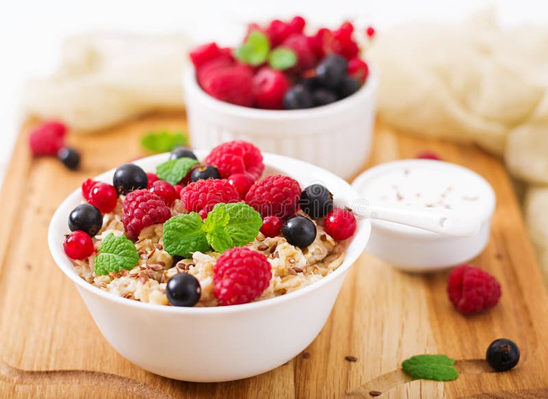 Tasty and healthy oatmeal porridge with berry, flax seeds and yogurt.