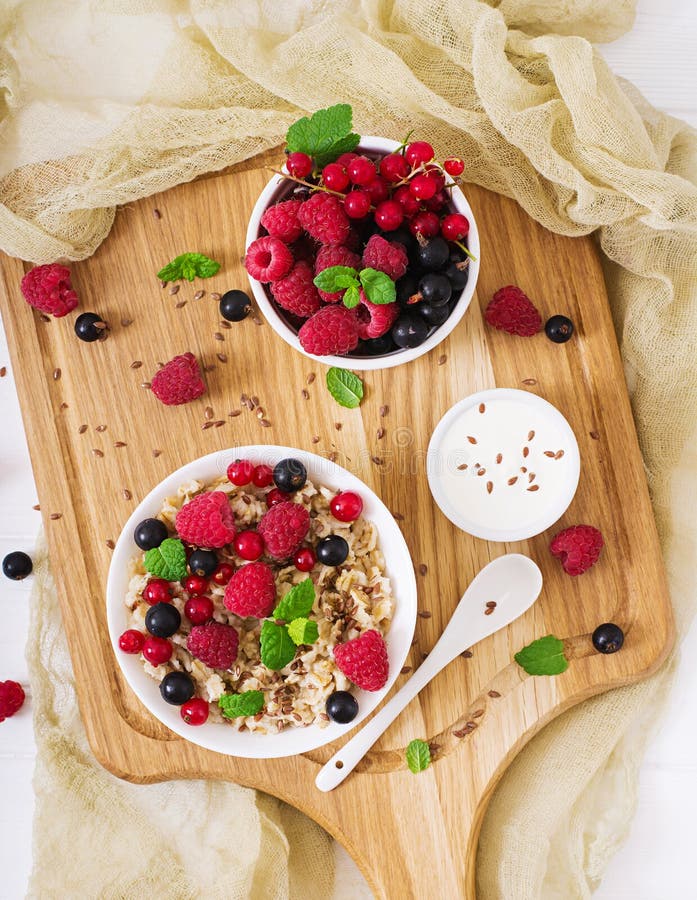 Tasty and healthy oatmeal porridge with berry, flax seeds and yogurt.