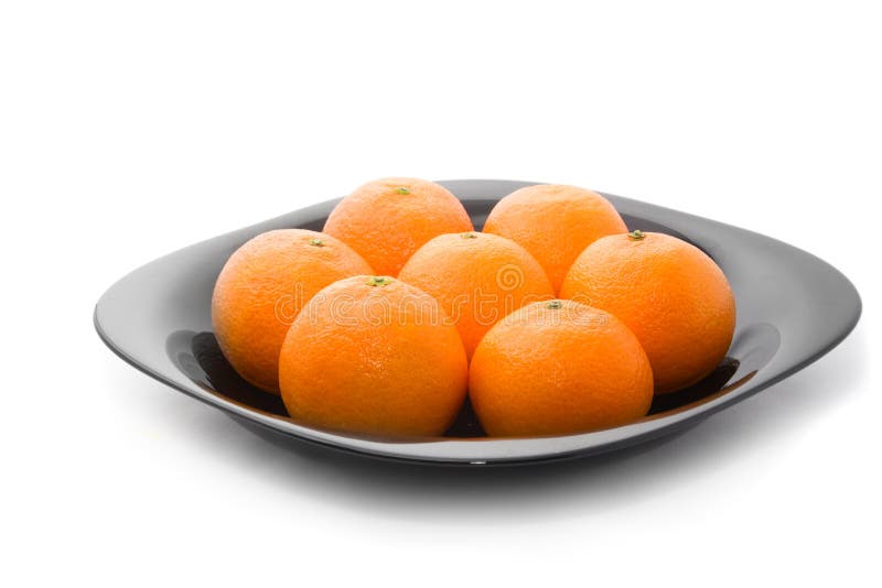 Tasty orange tangerins on black plate