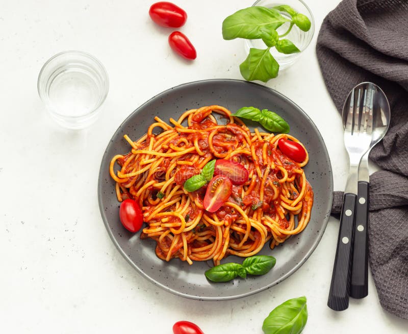 Tasty pasta with spicy tomato sauce, cherry tomatoes and basil.