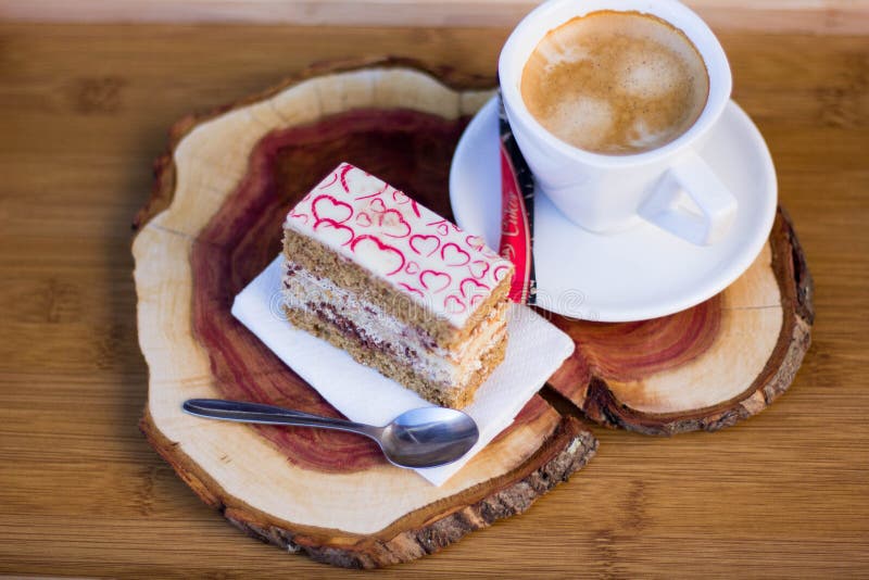 Tasty Slice of Cake with Cream Filling and Heart Decor on Top with Coffee