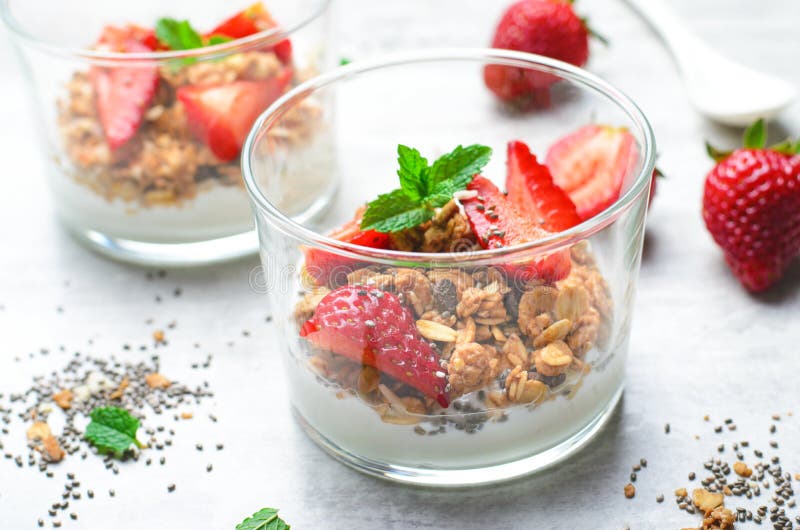 Tasty Strawberry Dessert, Homemade Yogurt with Strawberries, Granola and Chia Seeds over Bright Background