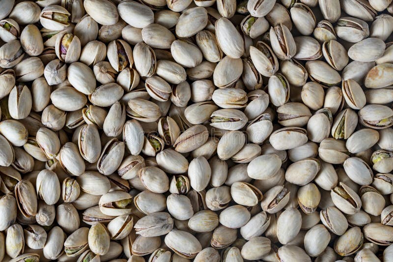 Tasty unpeeled pistachios , top view, close up. Pistachios texture and background. Pile pistachio kernels nuts with shells