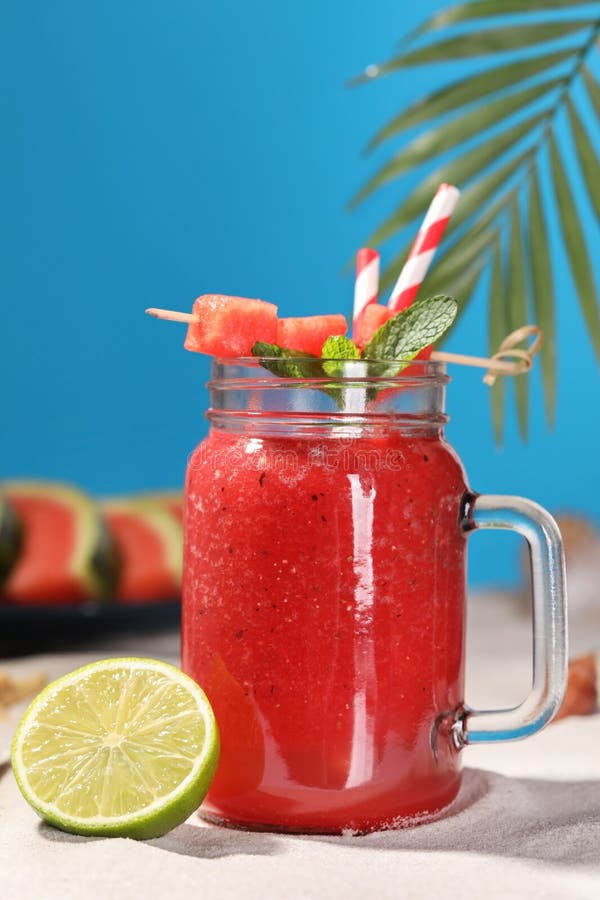 Tasty Watermelon Drink with Lime in Mason Jar on Sand Stock Image