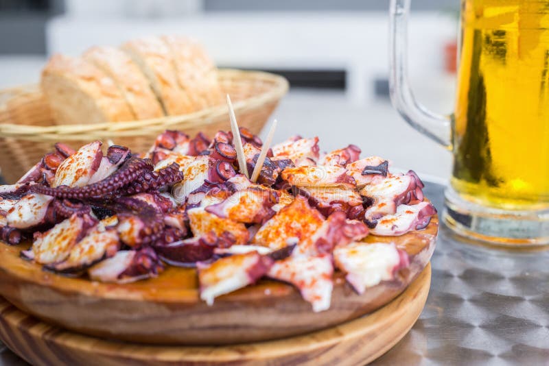 Tasty Wooden plate of galician style cooked octopus with paprika and olive oil. Pulpo a la gallega royalty free stock photography Tasty Wooden plate of galician style cooked octopus with paprika and olive oil. Pulpo a la gallega royalty free stock photography