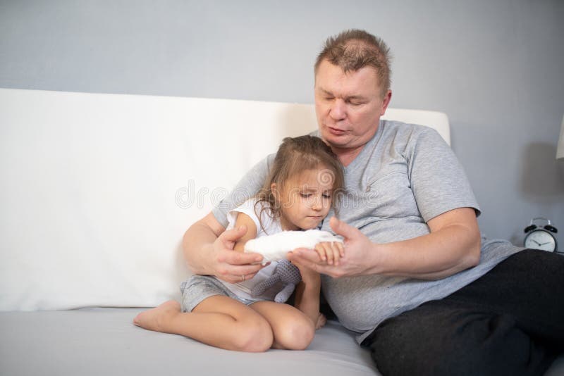 Tata lituje się, że córka gips na ramieniu zdjęcia stock