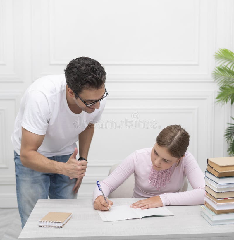 Tata și fiica studiind împreună online acasă. Explicând lecția și ascultându-l cu atenție royalty free stock photos