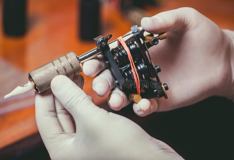 Tatoegeringskunstenaar in witte handschoenen die klaar om een tatoegering te doen worden stock afbeeldingen Tatoegeringskunstenaar in witte handschoenen die klaar om een tatoegering te doen worden stock afbeeldingen