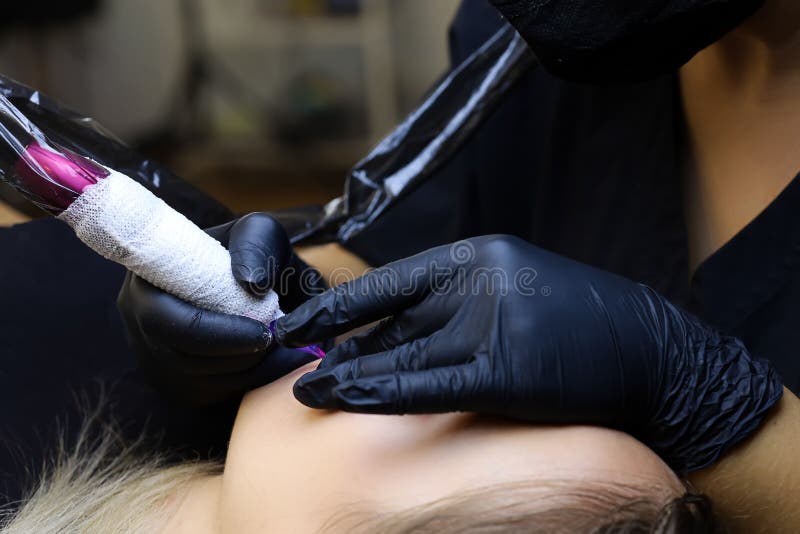 Tattoo Artist is Bent Over the Model Holding His Lips and with the Other  Hand Performs Permanent Makeup with a Tattoo Machine Stock Photo - Image of  care, caucasian: 229935758