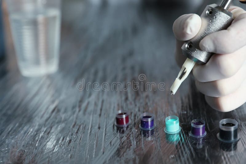 Tattoo Artist with Machine and Ink at Table Stock Image Image of