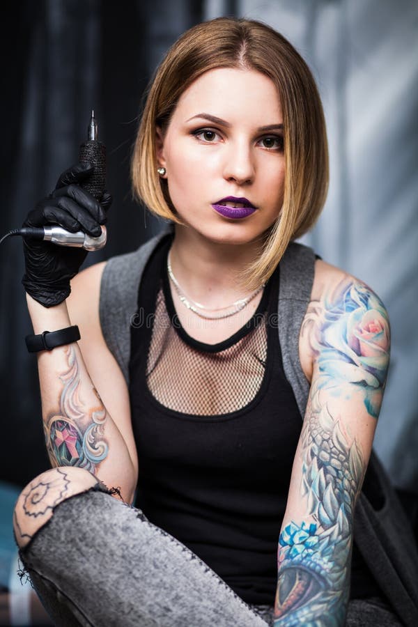Tattoo artist in a studio stock image. Image of gloves 93855761