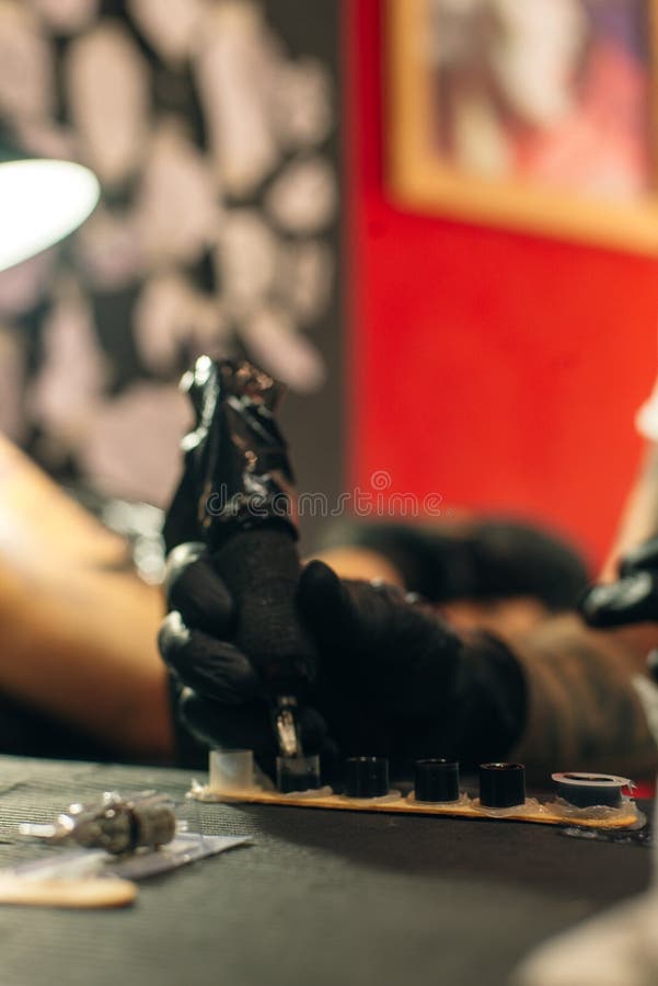 Tattoo Artist Workplace with Machine and Bottles with Black Tattoo Ink