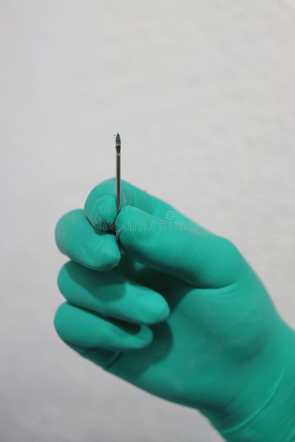 Hand with Green Glove and Needle Stock Photo Image of bead, piercing