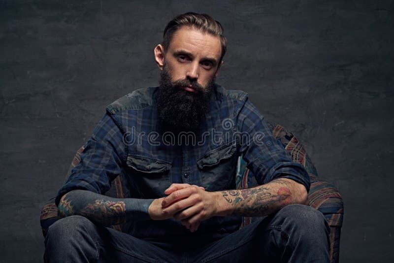 Tattooed Bearded Male Sits on a Chair. Stock Photo - Image of chair ...