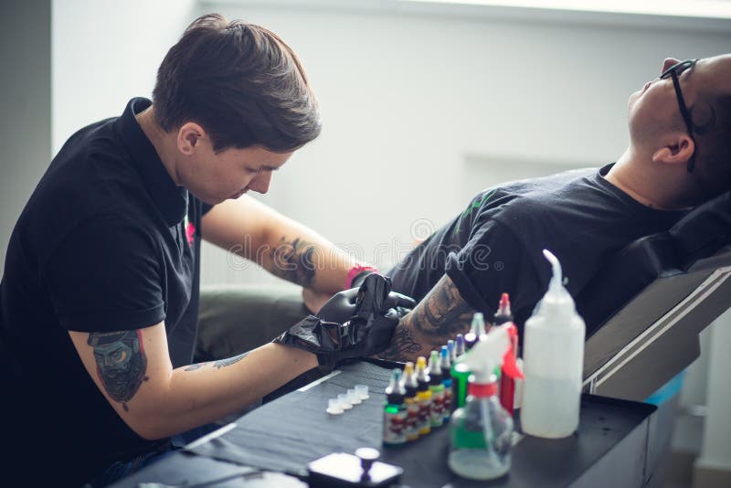 A Máquina Da Tatuagem Faz O Desenho Na Mão Masculina Foto de Stock - Imagem  de multicor, menina: 109774244