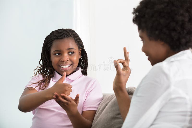 Taube Mutter-Unterhaltungsgebärdensprache mit ihrer Tochter stockfoto