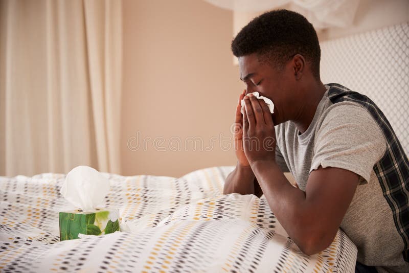 Tausendjähriger Afroamerikanermann, der oben in der Bettschlagnase, Seitenansicht, Abschluss oben sitzt lizenzfreie stockfotografie