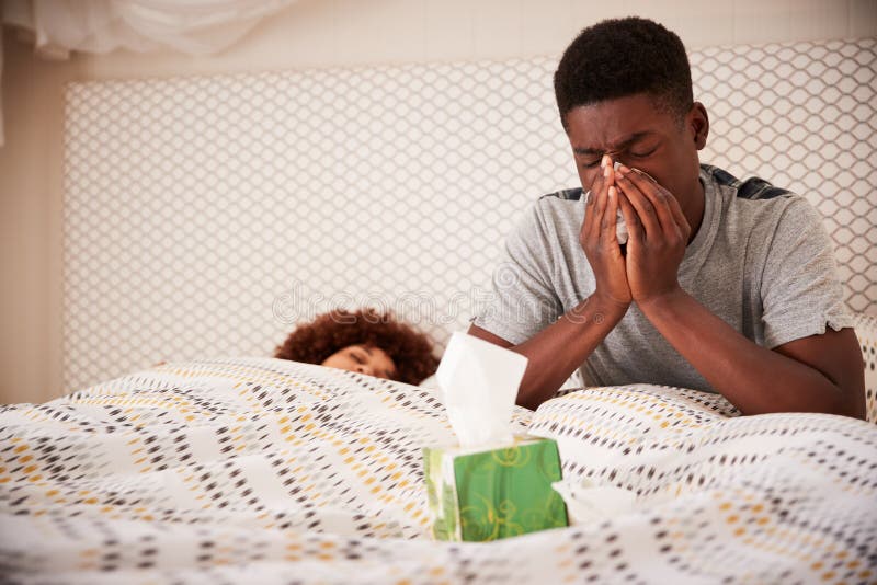 Tausendjähriger Afroamerikanermann, der oben in der Bettschlagnase sitzt, während sein Partner schläft, Abschluss oben lizenzfreies stockbild
