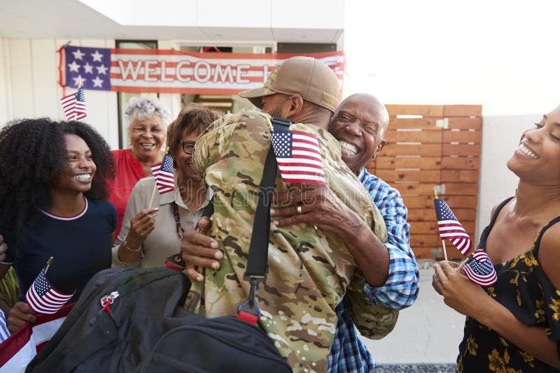 Tausendjähriger Afroamerikanersoldat, der nach Hause zu seiner Familie, Großvater umfassend, hintere Ansicht zurückkommt lizenzfreie stockbilder