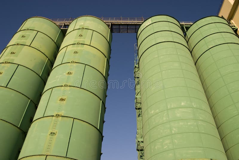 Bright green storage silos against a blue sky. Bright green storage silos against a blue sky