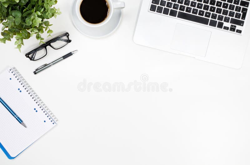 Tavola della scrivania con il computer portatile, la tazza di caffè e la vista superiore dei rifornimenti Tavola della scrivania con il computer portatile, la tazza di caffè e la vista superiore dei rifornimenti