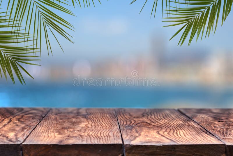 Tavola di legno o derisione di legno su con le palme contro lo sfondo di una città confusa immagini stock libere da diritti Tavola di legno o derisione di legno su con le palme contro lo sfondo di una città confusa immagini stock libere da diritti