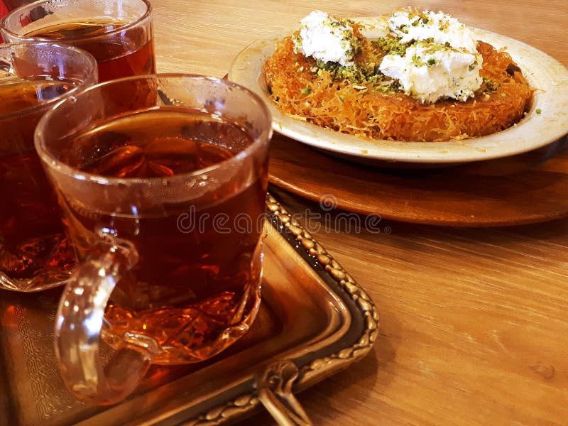 End of a workday with attractive evening table ,  fragrant tea and Turkish baklava called kunafa. End of a workday with attractive evening table ,  fragrant tea and Turkish baklava called kunafa