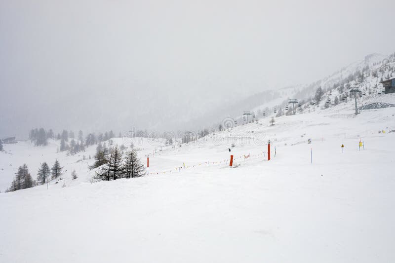 Tavoli di legno vuoti in un bar presso una stazione sciistica delle Alpi in cattivo tempo