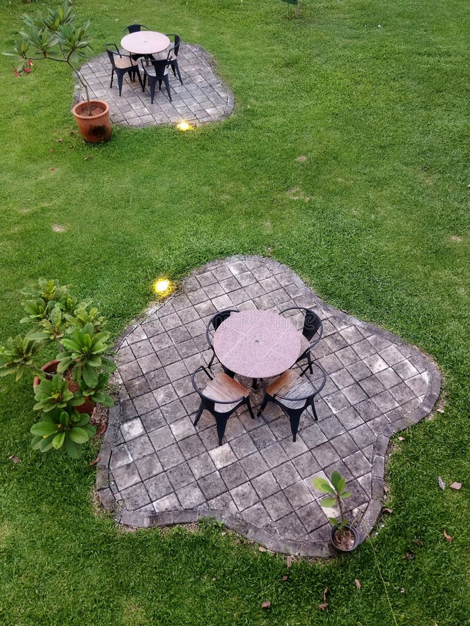 1 table and 4 banquet chairs in the middle of the island among the green grass. Photo angle taken from above. 1 table and 4 banquet chairs in the middle of the island among the green grass. Photo angle taken from above.