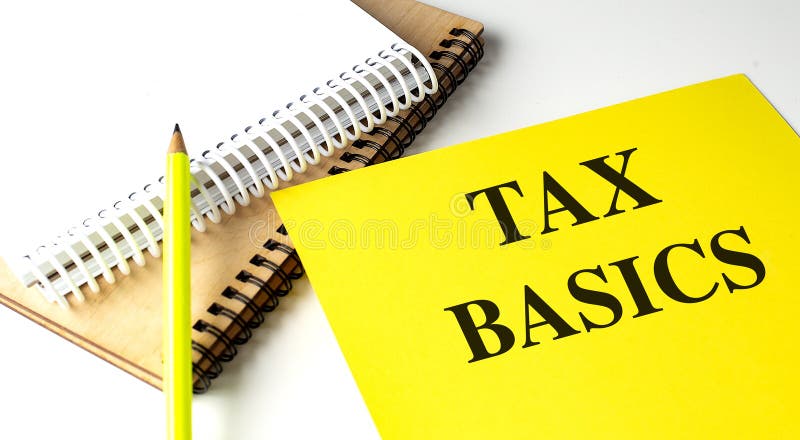 TAX BASICS text on yellow paper with notebooks stock photo