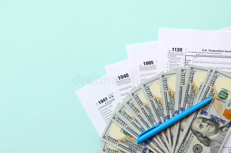 Tax forms lies near hundred dollar bills and blue pen on a light blue background. Income tax return royalty free stock photography Tax forms lies near hundred dollar bills and blue pen on a light blue background. Income tax return royalty free stock photography